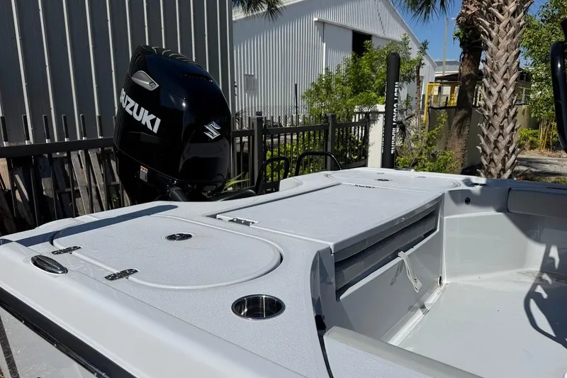 Slide: The Image of 2027 Blazer Bay 2440 boat with Suzuki outboard motor, docked near industrial buildings. - 8