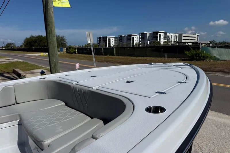 Slide: The Image of 2027 Blazer Bay 2440 boat with sleek seating and modern design, parked near a road. - 5