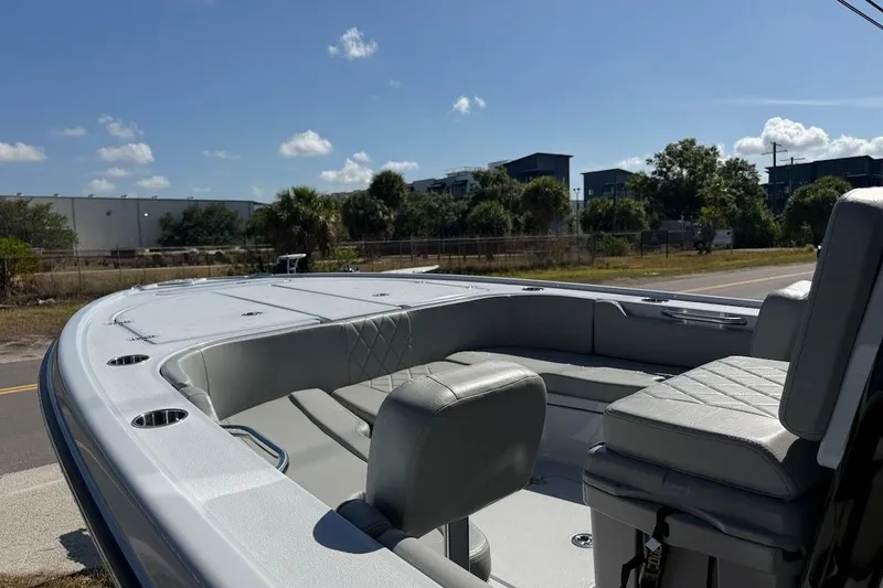 Slide: The Image of 2027 Blazer Bay 2440 boat interior with seating, under a clear blue sky. - 15