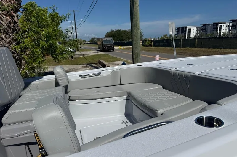Slide: The Image of 2027 Blazer Bay 2440 boat interior with gray seating, parked near a road. - 4