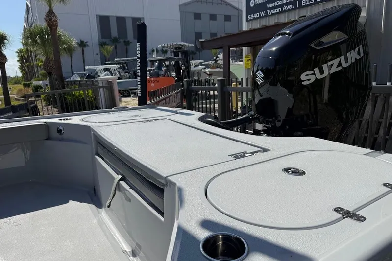 Slide: The Image of 2027 Blazer Bay 2440 boat with Suzuki outboard motor, docked near palm trees. - 14