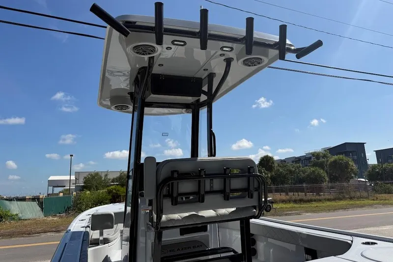 Slide: The Image of 2027 Blazer Bay 2440 boat with T-top and rod holders under clear sky. - 13