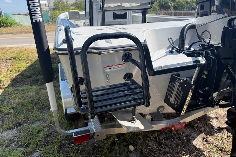 Slide: The Image of 2027 Blazer Bay 2440 boat with ladder and motor, parked on a trailer. - 12