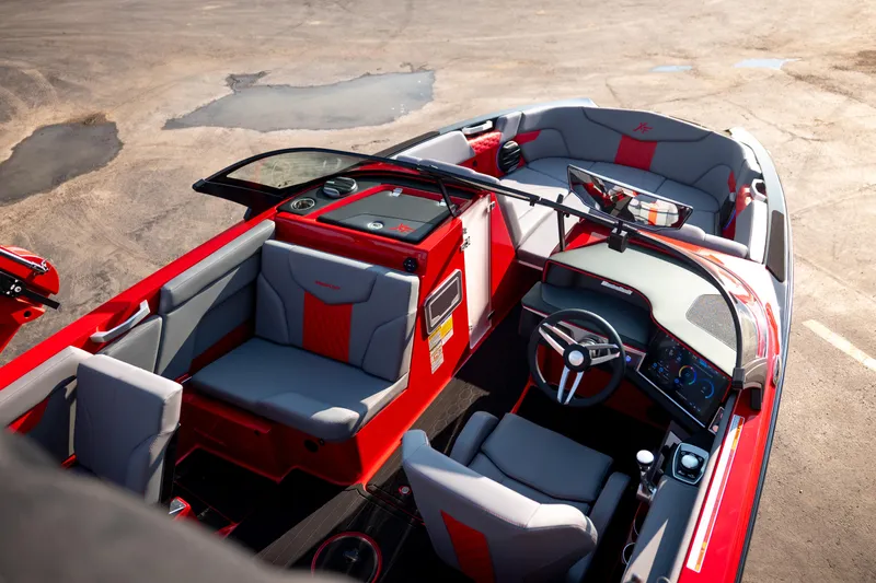 Slide: The Image of 2027 MasterCraft XT24 boat interior with red and gray seating, modern dashboard, and steering wheel. - 31