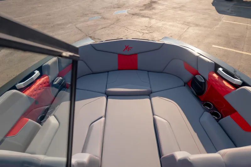 Slide: The Image of Interior of 2027 MasterCraft XT24 boat with gray and red seating, cup holders, and speaker. - 17