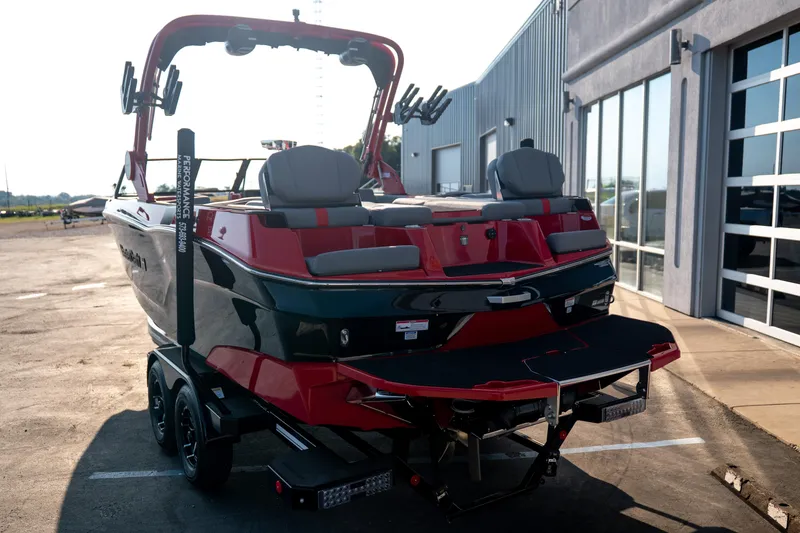 Slide: The Image of 2027 MasterCraft XT24 boat on trailer, parked outside a modern building. - 8