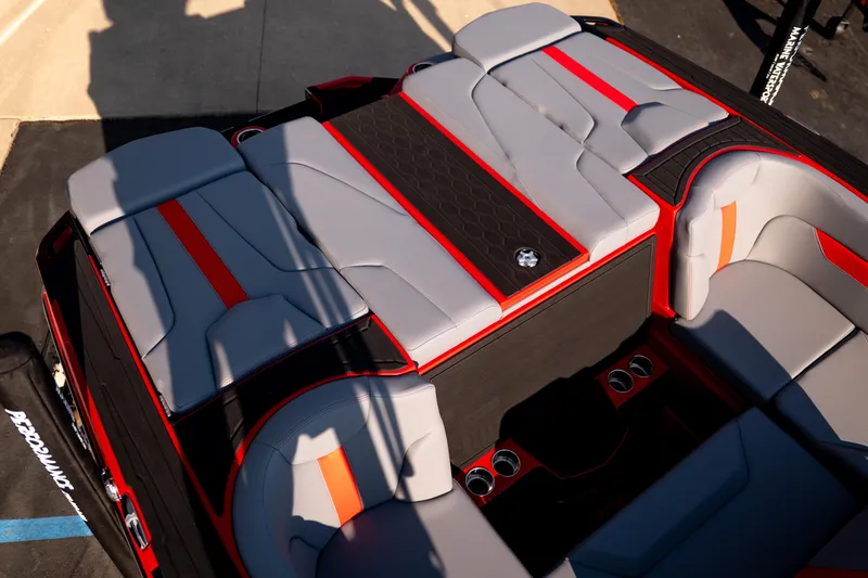 Slide: The Image of 2027 MasterCraft XT24 boat interior with gray and red seating, cup holders, and sleek design. - 34