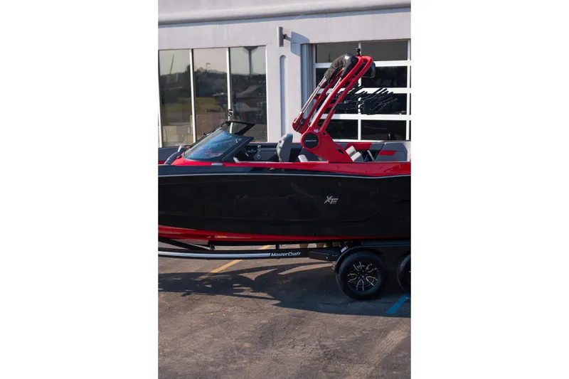 Slide: The Image of 2027 MasterCraft XT24 boat in black and red, parked on a trailer. - 4