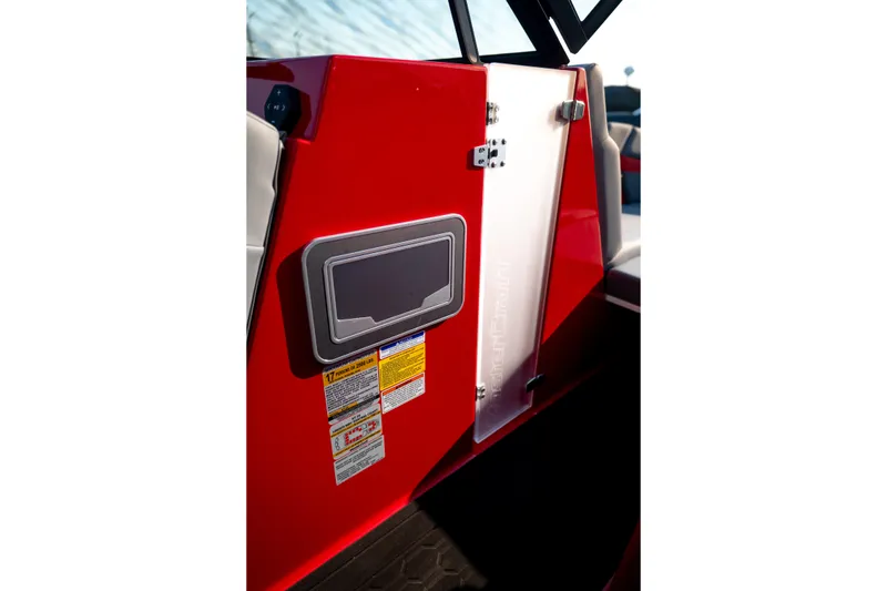 Slide: The Image of Red 2027 MasterCraft XT24 boat interior with safety labels and storage compartment. - 29