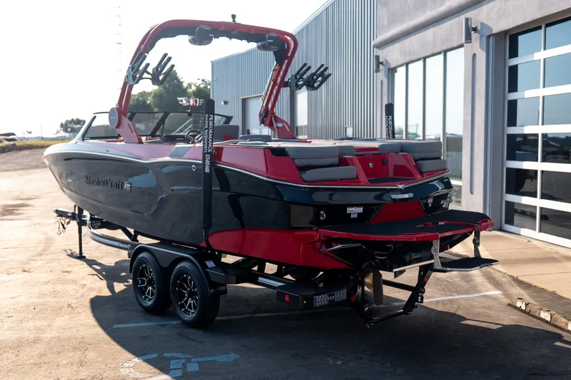 Slide: The Image of 2027 MasterCraft XT24 boat on trailer, parked outside a modern building. - 6