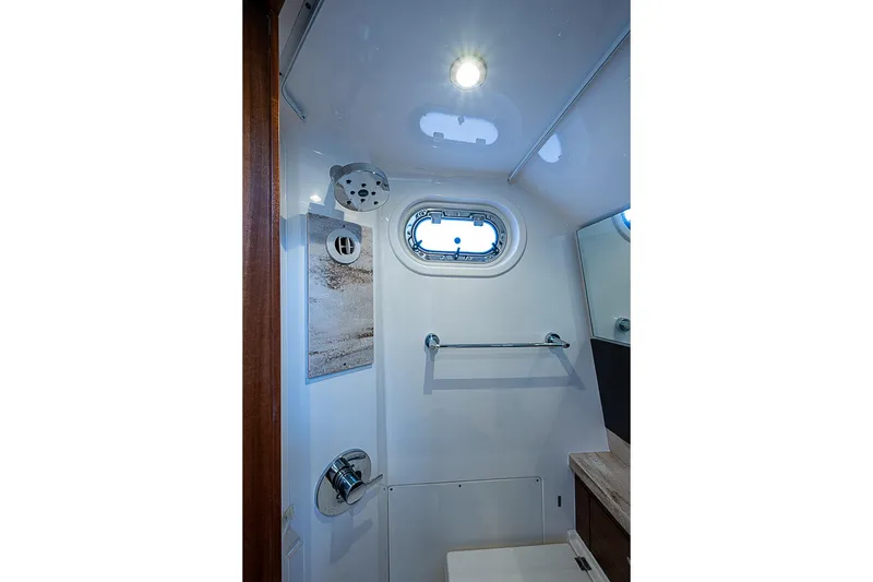Slide: The Image of 2020 Pursuit S 368 Sport boat bathroom with porthole, towel rack, and modern fixtures. - 46