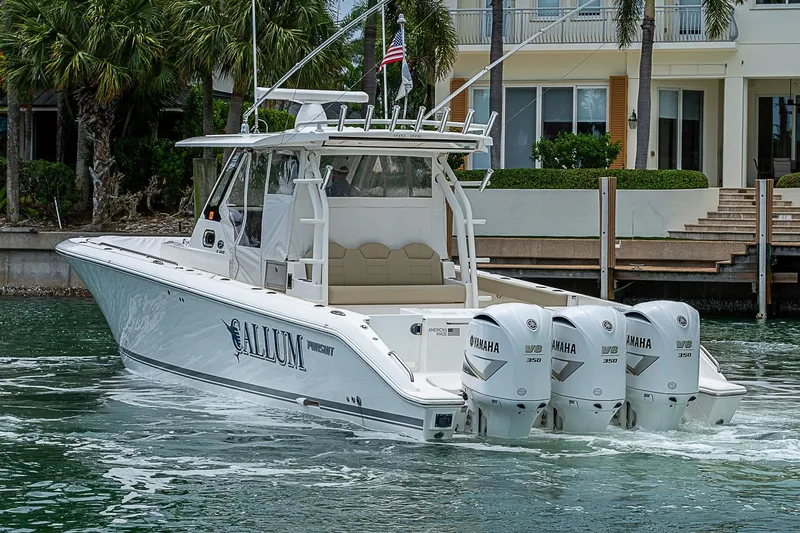 Slide: The Image of 2020 Pursuit S 368 Sport boat with triple Yamaha V8 engines, docked near waterfront home. - 18