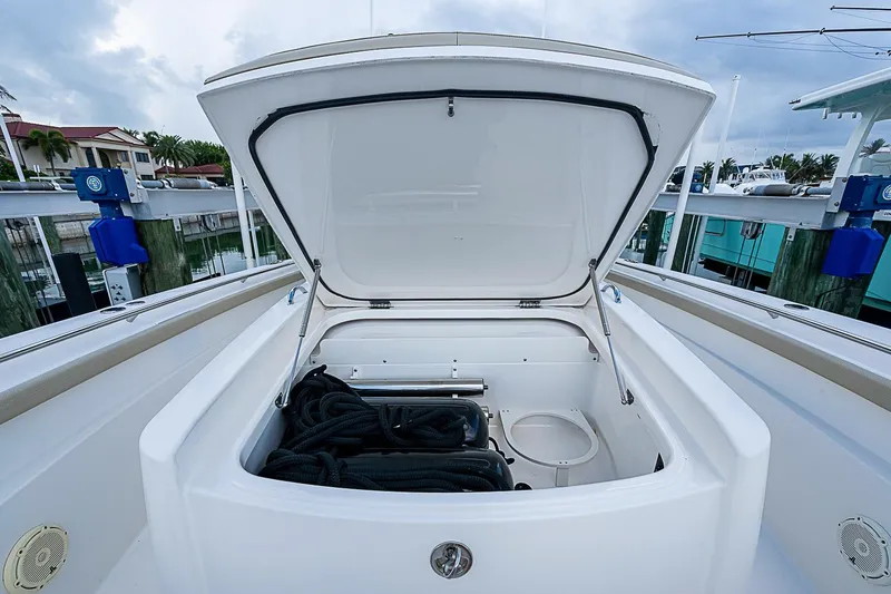 Slide: The Image of 2020 Pursuit S 368 Sport boat storage compartment open, showing ropes inside. - 42