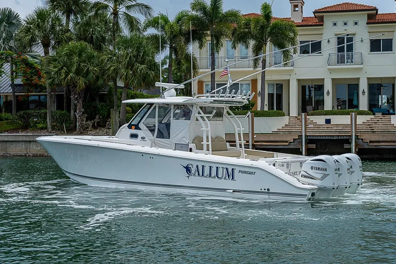 Slide: The Image of 2020 Pursuit S 368 Sport boat cruising near waterfront property with palm trees. - 15