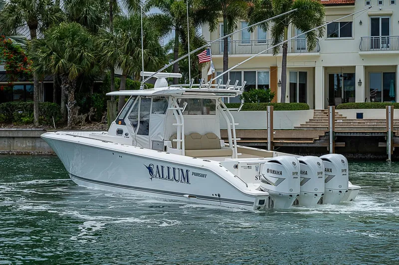 Slide: The Image of 2020 Pursuit S 368 Sport boat with triple Yamaha engines near waterfront homes. - 17