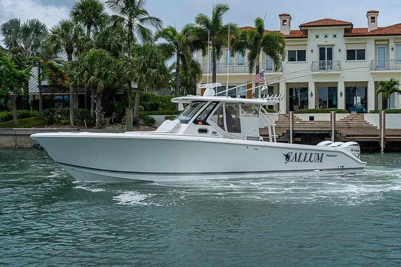 Slide: The Image of 2020 Pursuit S 368 Sport boat cruising near luxury waterfront property. - 10