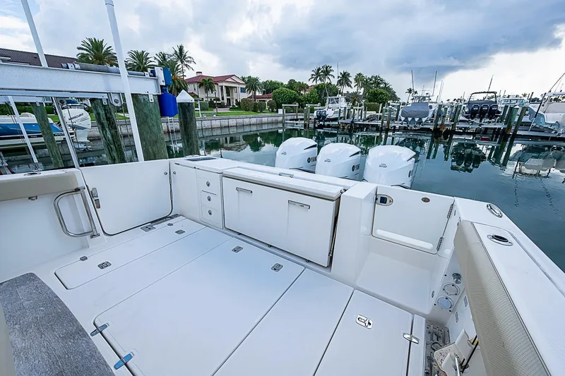 Slide: The Image of 2020 Pursuit S 368 Sport boat docked, featuring spacious deck and triple Yamaha engines. - 26