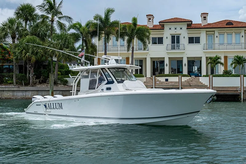 Slide: The Image of 2020 Pursuit S 368 Sport boat cruising near luxury waterfront mansion. - 3