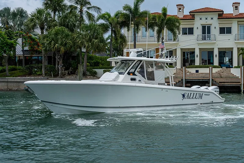 Slide: The Image of 2020 Pursuit S 368 Sport boat cruising near waterfront mansion with palm trees. - 9