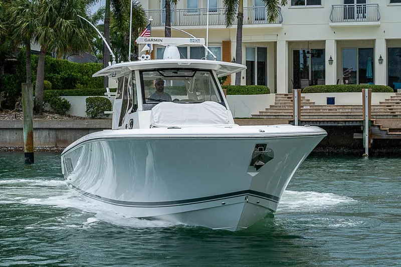 Slide: The Image of 2020 Pursuit S 368 Sport boat cruising near waterfront homes. - 6