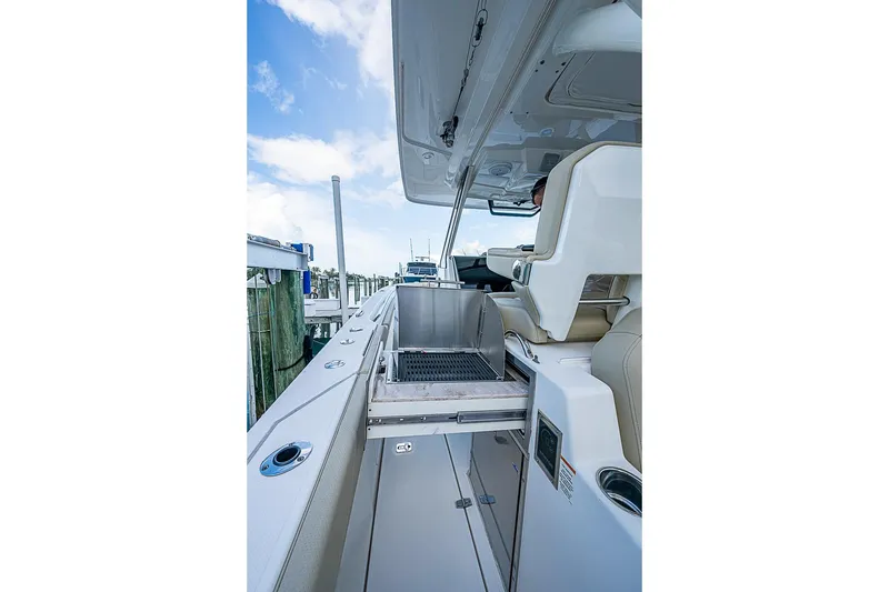 Slide: The Image of 2020 Pursuit S 368 Sport boat interior with grill and seating area. - 33