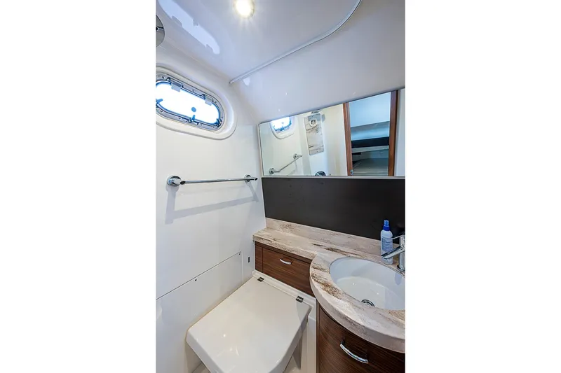 Slide: The Image of 2020 Pursuit S 368 Sport boat bathroom with modern sink and porthole window. - 44