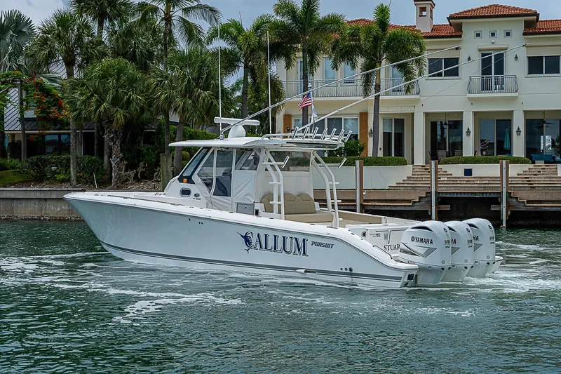 Slide: The Image of 2020 Pursuit S 368 Sport boat cruising near waterfront mansion with palm trees. - 16