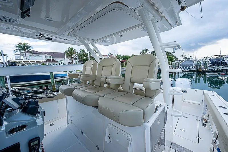 Slide: The Image of 2020 Pursuit S 368 Sport boat interior with luxurious seating and helm, docked at marina. - 23
