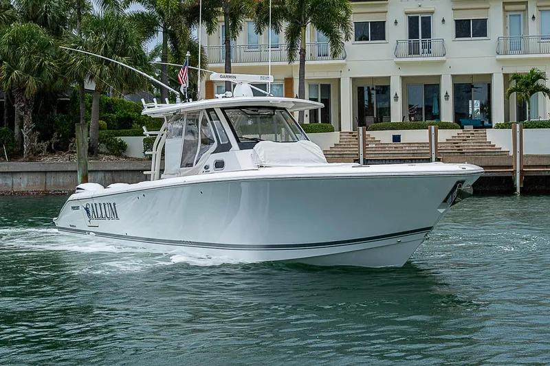 Slide: The Image of 2020 Pursuit S 368 Sport boat cruising near waterfront property with palm trees. - 4
