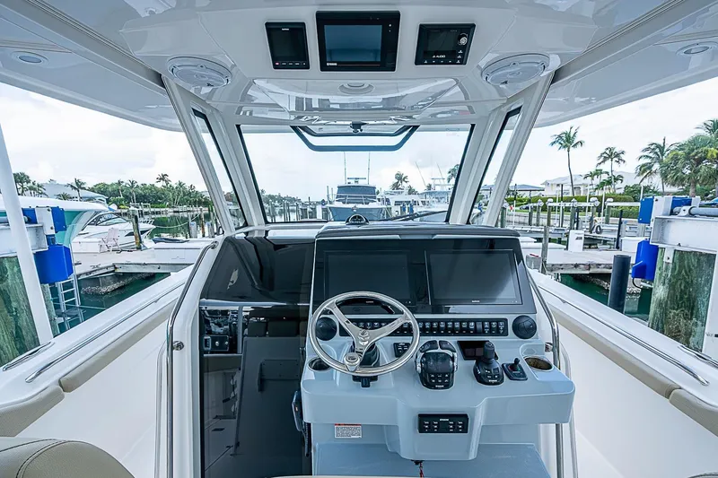 Slide: The Image of Cockpit view of 2020 Pursuit S 368 Sport boat at marina, featuring modern controls and displays. - 21