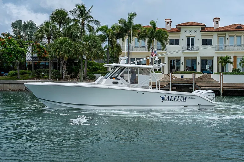 Slide: The Image of 2020 Pursuit S 368 Sport boat cruising near luxury waterfront home. - 11