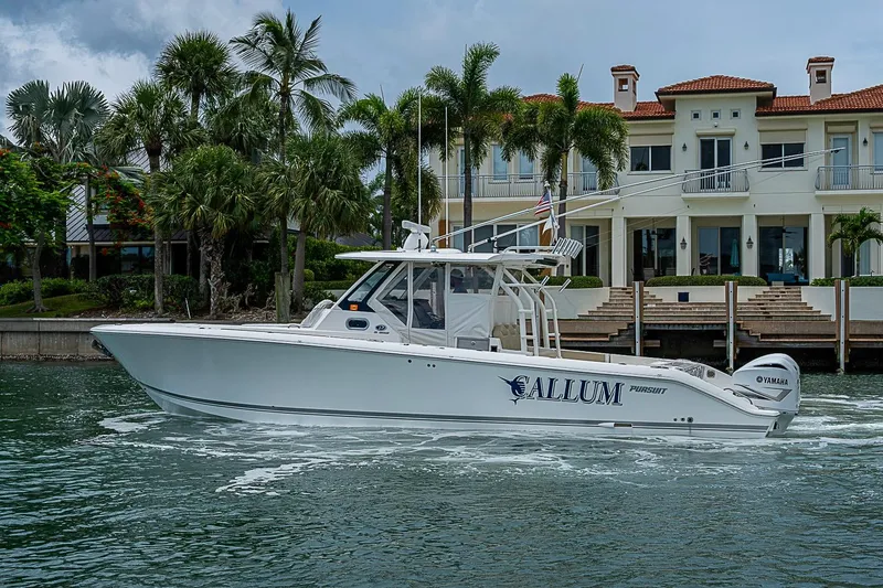 Slide: The Image of 2020 Pursuit S 368 Sport boat cruising near luxury waterfront property. - 13