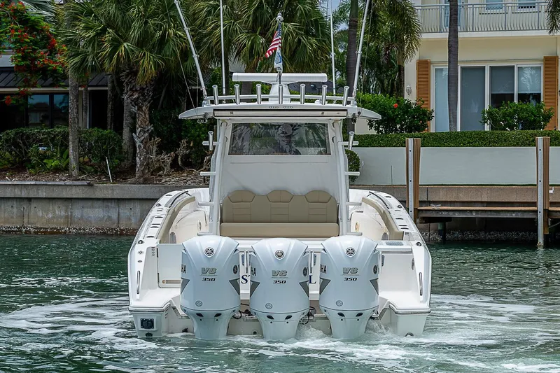 Slide: The Image of 2020 Pursuit S 368 Sport boat with triple V8 engines, docked near waterfront home. - 19