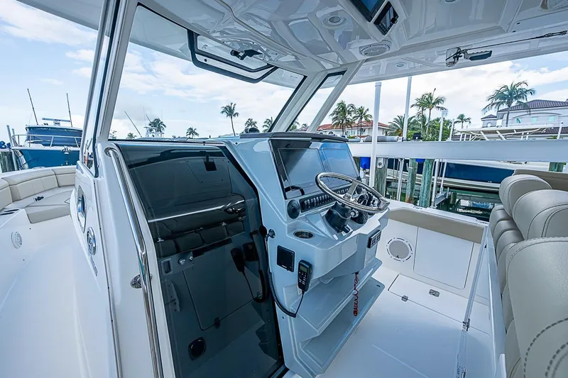 Slide: The Image of 2020 Pursuit S 368 Sport boat interior with helm, steering wheel, and seating. - 20