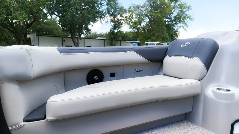 Slide: The Image of The image shows a luxurious seat on a Barletta SANZA 22UC boat, surrounded by trees. - 16
