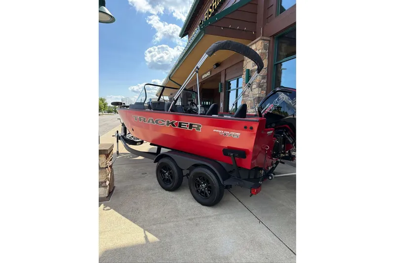 Slide: The Image of 2026 Tracker Pro Guide V-175 WT boat in vibrant red on a trailer, parked outdoors. - 63