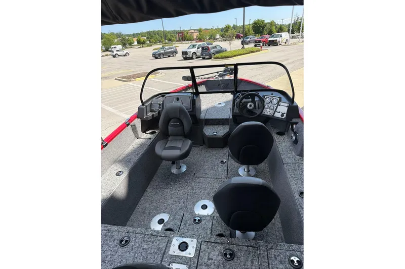 Slide: The Image of 2026 Tracker Pro Guide V-175 WT boat interior with seating and dashboard in a parking lot. - 68