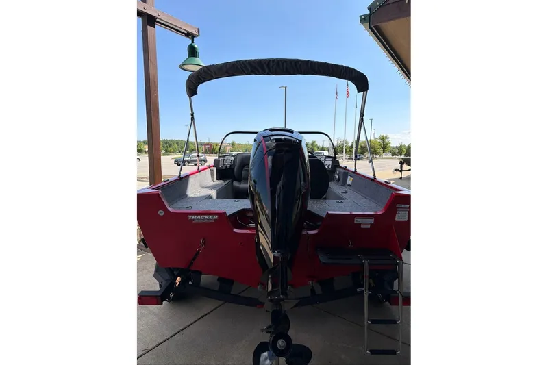 Slide: The Image of 2026 Tracker Pro Guide V-175 WT boat, rear view, red exterior, parked outdoors. - 64
