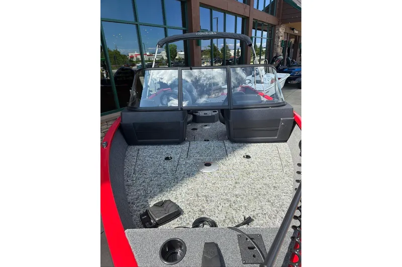 Slide: The Image of 2026 Tracker Pro Guide V-175 WT boat with spacious deck and windshield, parked outdoors. - 67