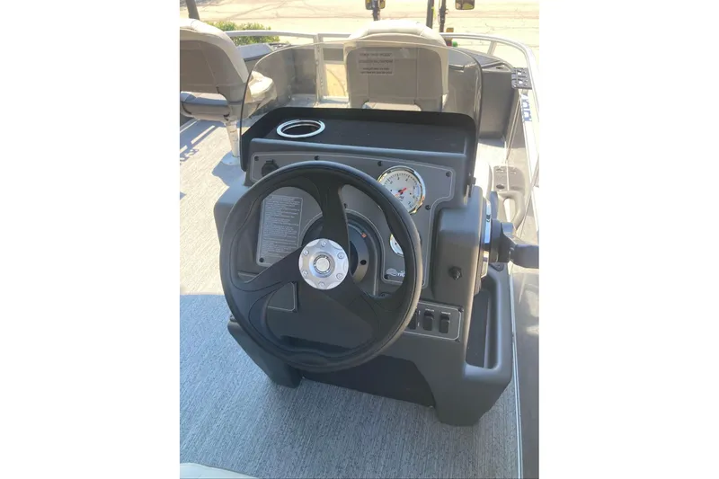 Slide: The Image of 2026 Sun Tracker Bass Buggy 18 DLX steering console with gauges and cup holder. - 1