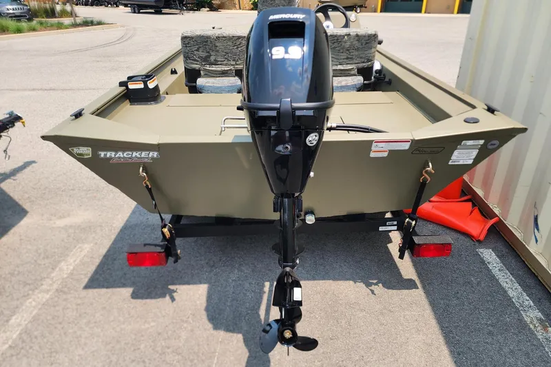 Slide: The Image of 2026 Tracker Grizzly 1754 SC boat with Mercury 9.9 motor, parked on trailer. - 2