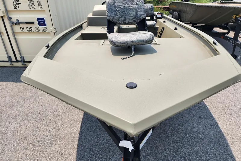 Slide: The Image of 2026 Tracker Grizzly 1754 SC boat with camouflage seating, parked outdoors. - 3