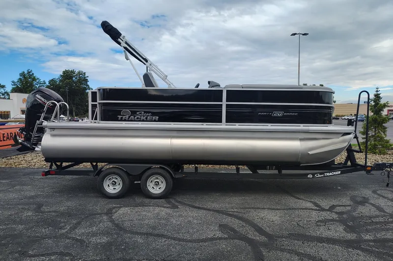 The Image of 2026 Sun Tracker Party Barge 20 DLX pontoon boat on trailer, parked outdoors. - 0