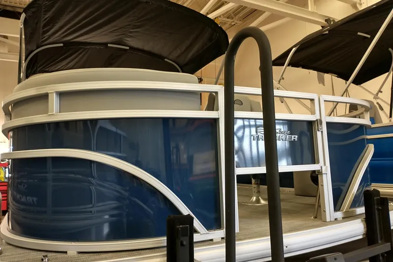 Slide: The Image of 2026 Sun Tracker SportFish 20 DLX pontoon boat with blue exterior in showroom. - 4