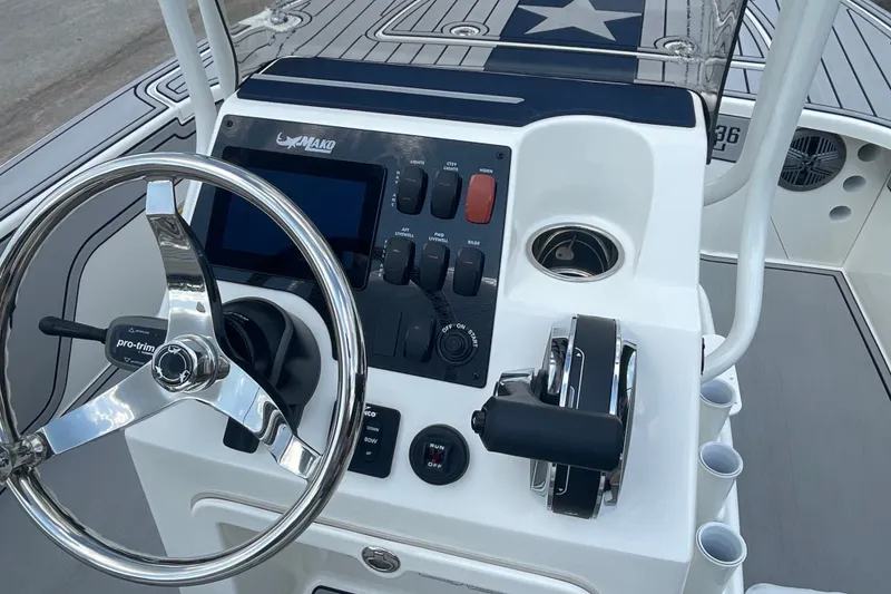 Slide: The Image of 2026 Mako 18 Pro Skiff Patriot Edition boat console with steering wheel and controls. - 10