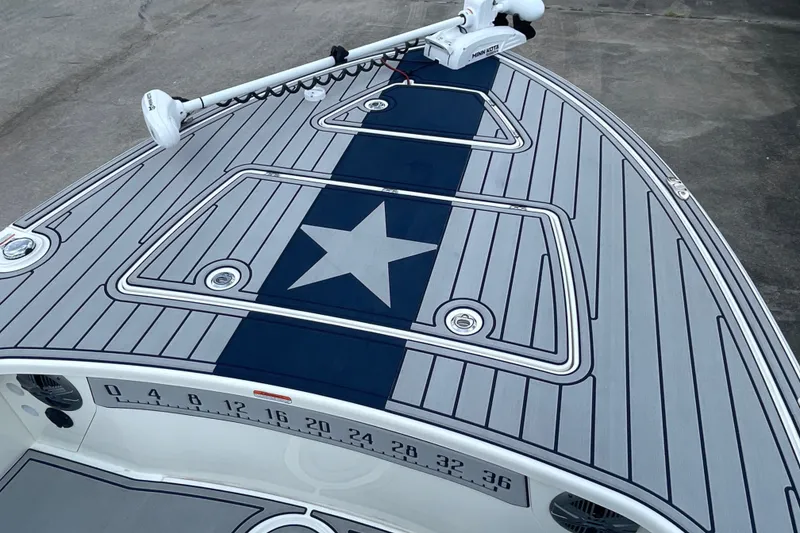 Slide: The Image of 2026 Mako 18 Pro Skiff Patriot Edition boat deck with star design and trolling motor. - 8