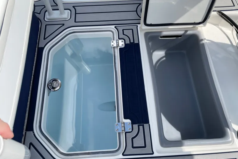 Slide: The Image of 2026 Mako 18 Pro Skiff Patriot Edition boat storage compartments, open and ready for use. - 19