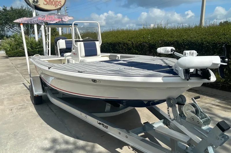 Slide: The Image of 2026 Mako 18 Pro Skiff Patriot Edition boat on trailer, parked outdoors. - 5
