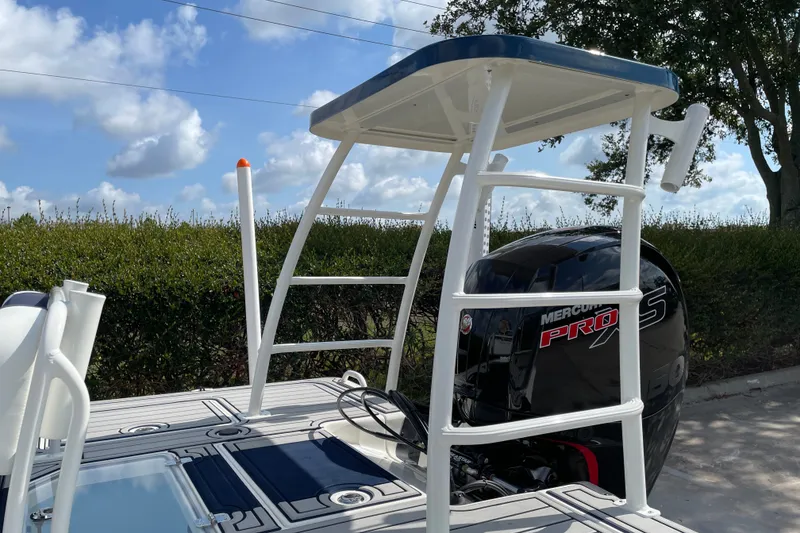 Slide: The Image of 2026 Mako 18 Pro Skiff Patriot Edition with Mercury Pro XS engine, under a clear sky. - 16