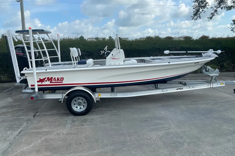 Slide: The Image of 2026 Mako 18 Pro Skiff Patriot Edition boat on trailer, parked outdoors. - 4